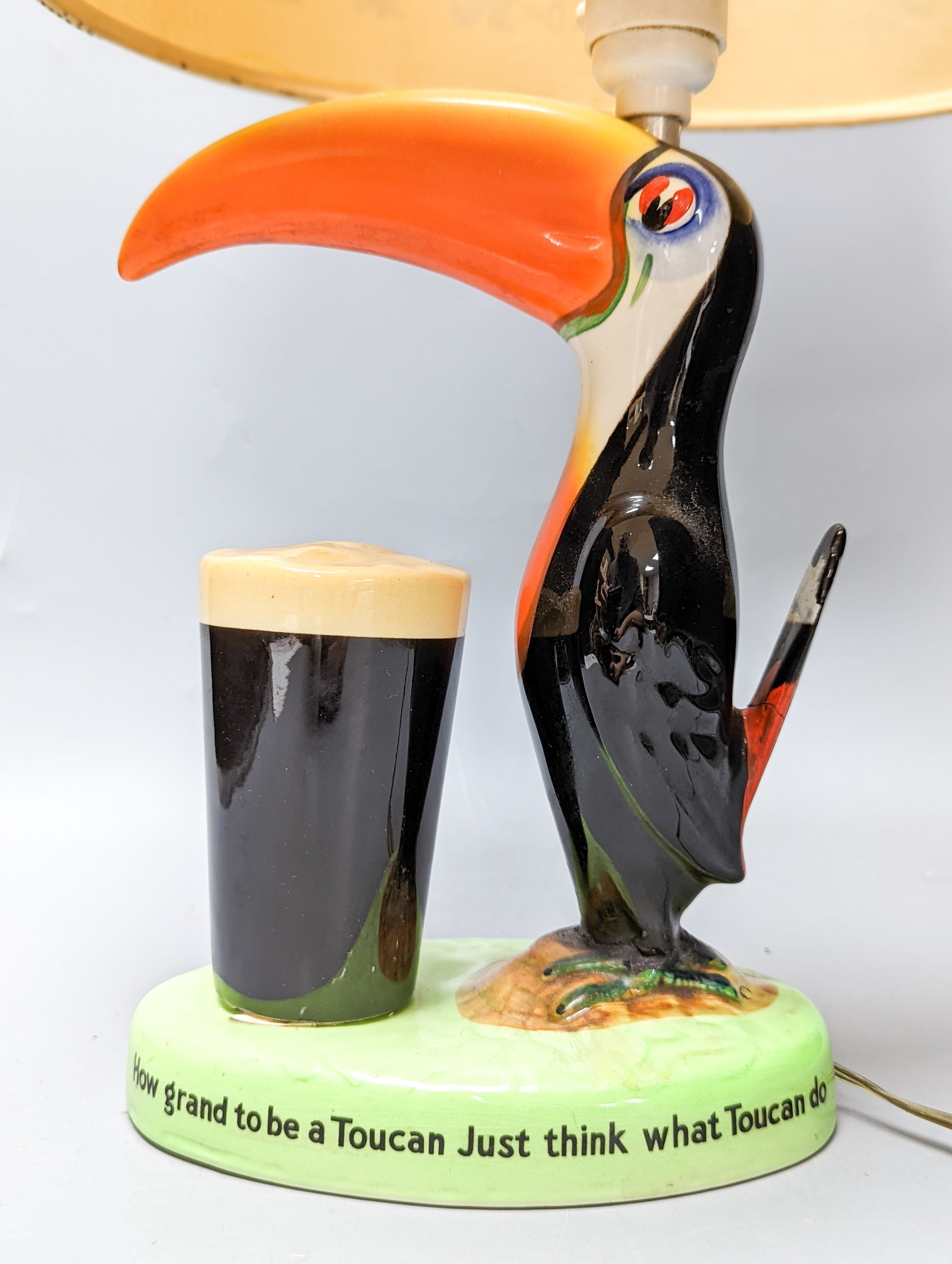 A Guinness toucan lamp, with original shade, tail repaired